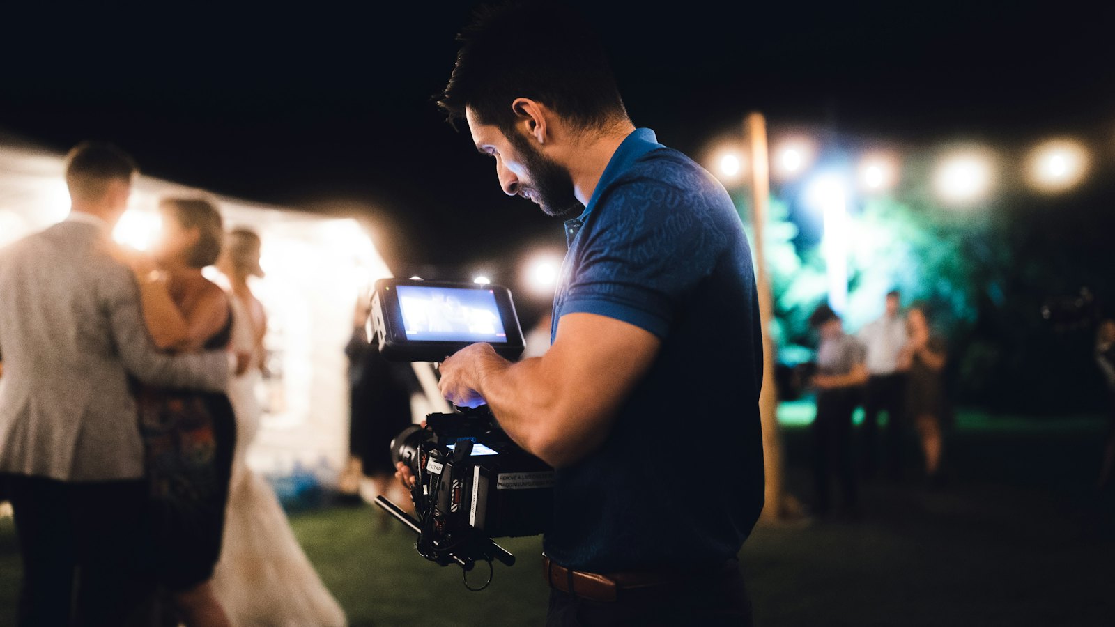 Cinegrafista filmando os noivos na pista de dança durante a festa